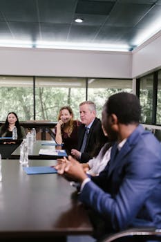 Corporate professionals engaged in an attentive meeting in a spacious conference room.